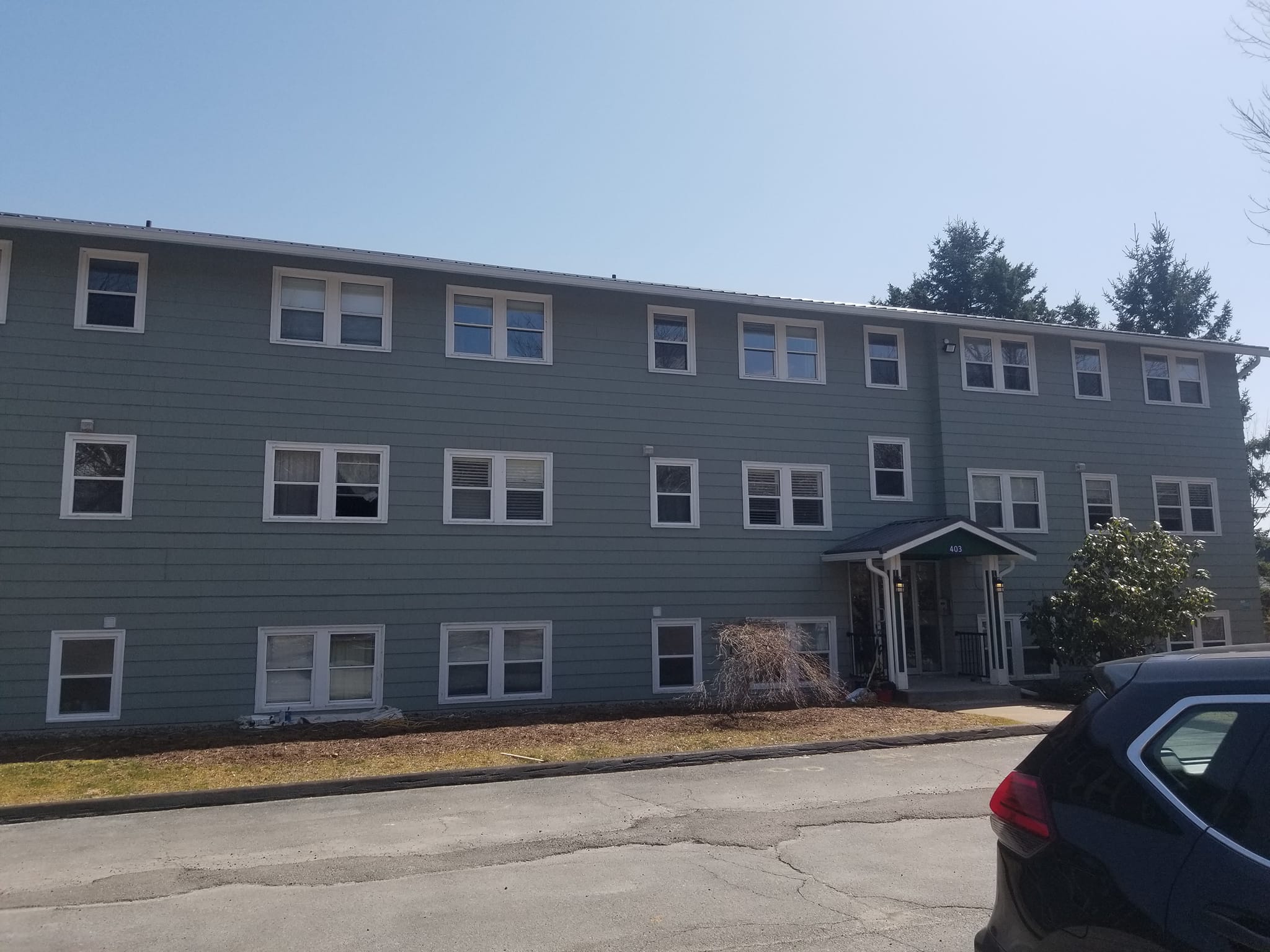 Multi-unit apartment building painted in slate grey