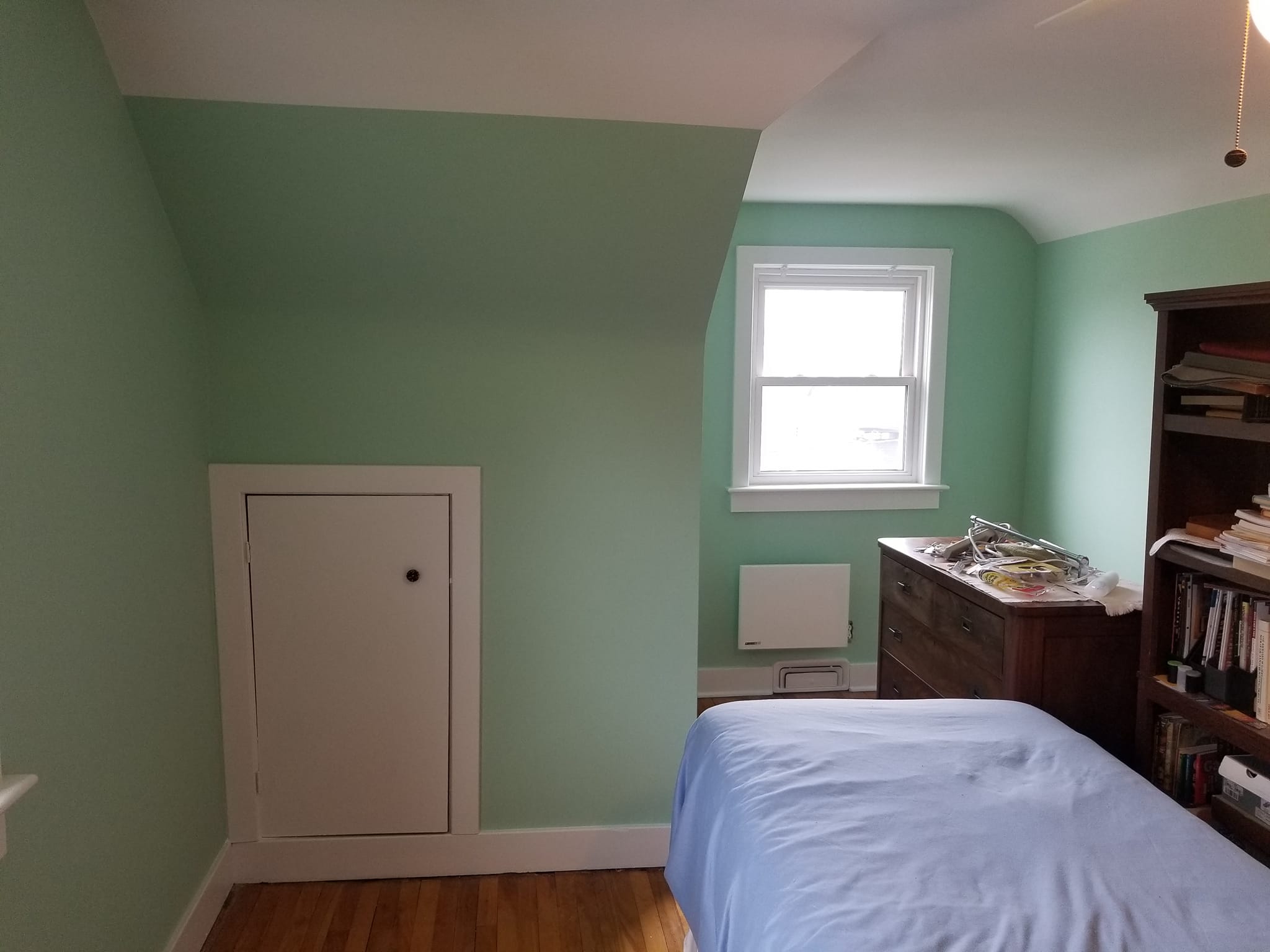 Bedroom painted in sage green with white trim